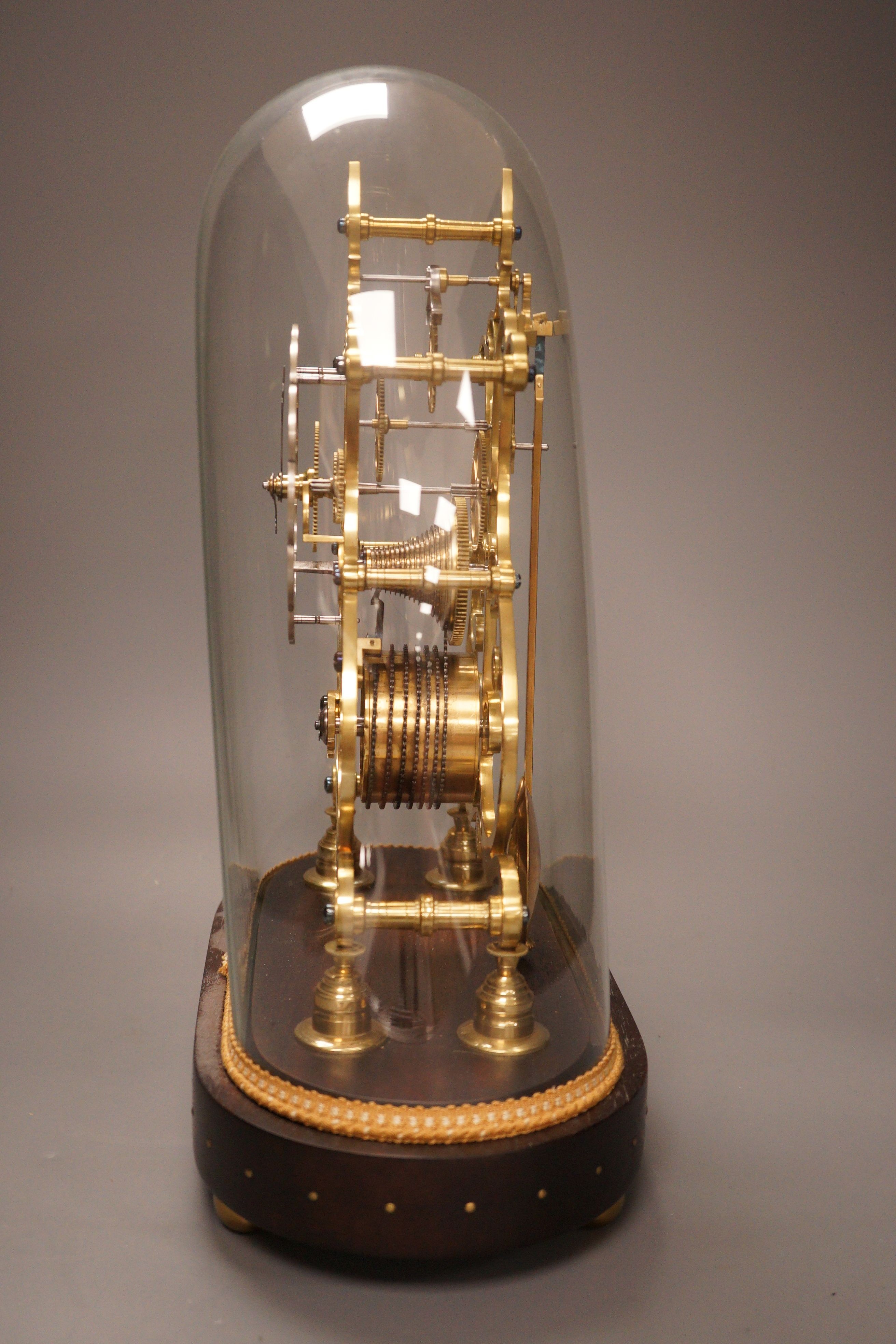 A 19th-century brass single fusee skeleton timepiece under dome, with wall bracket